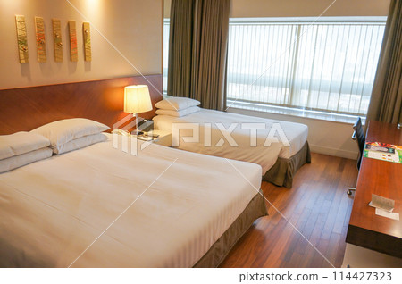 Twin beds in a hotel room Twin beds in a hotel room 114427323