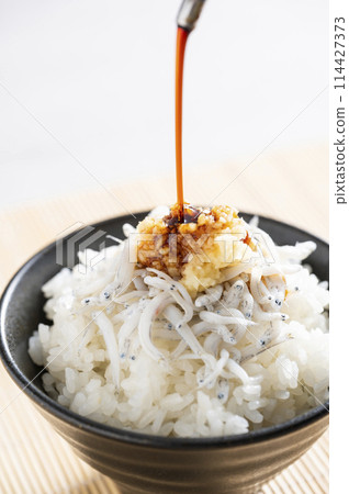 Pour soy sauce over whitebait and ginger rice Pour soy sauce over whitebait and ginger rice 114427373