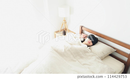 一個女人在明亮的房間裡戴著眼罩睡覺 一個女人在明亮的房間裡戴著眼罩睡覺 114429753