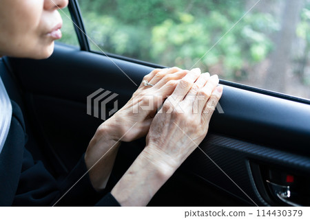 Woman in mourning clothes, car, hands 114430379
