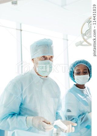 senior doctor talking with his assistants about future surgery senior doctor talking with his assistants about future surgery 114431819