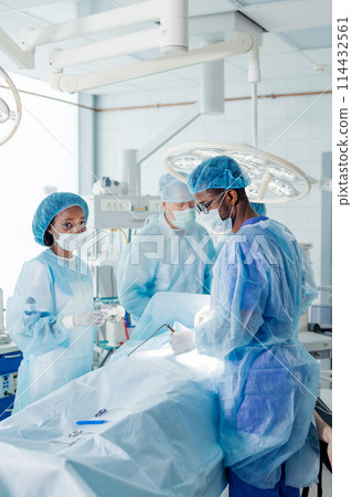 african and caucasian doctors perform the risky surgery african and caucasian doctors perform the risky surgery 114432561