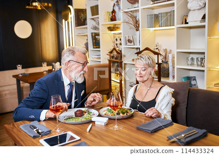 Mature couple having dinner at cafe Mature couple having dinner at cafe 114433324