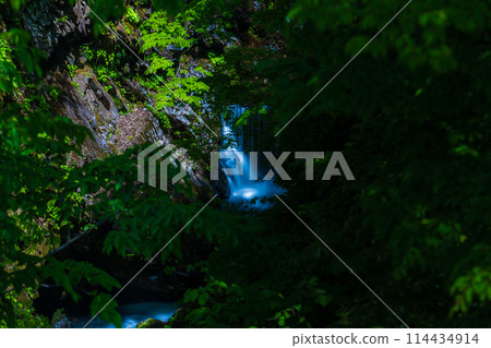 A waterfall running through a deep mountain valley A waterfall running through a deep mountain valley 114434914