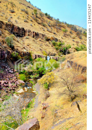 Mountain landscape of Uzbekistan. Foothills of the Pamirs. A small waterfall on a mountain river. AI-generated item 114435247