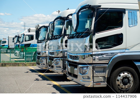 Large trucks lined up in a parking lot 114437906