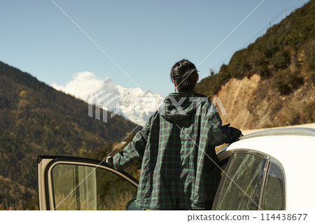 asian woman female tourist looking at snow covered mount kawaboge in yunnan, china 114438677