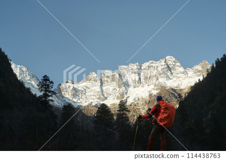 asian trekker looking at mount jiawaren-an of the meili snow mountains, china 114438763