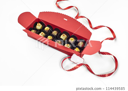 Exquisite chocolate candies in red gift box with dotted ribbon Exquisite chocolate candies in red gift box with dotted ribbon 114439585