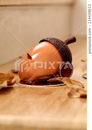 Chocolate acorn shaped cake in glossy hazelnut praline ganache 114439613