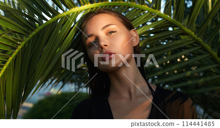 beautiful passion girl in palm leaves. young woman with Make-up under palm tree 114441485