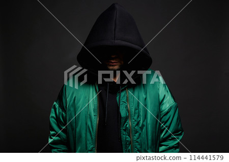 Man in Hood and green bomber jacket. Trendy wear Boy in a hooded sweatshirt 114441579