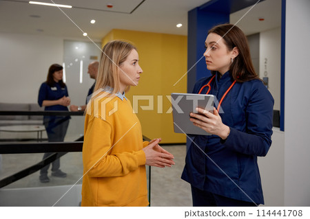 Woman having quick consultation with gynecologist in clinic corridor Woman having quick consultation with gynecologist in clinic corridor 114441708