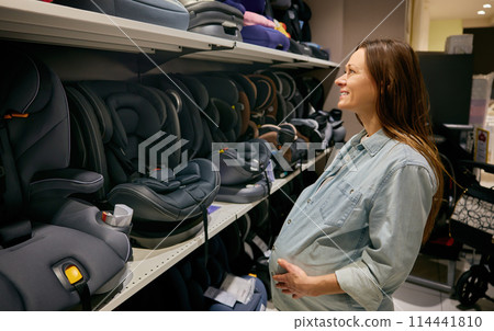 Pregnant woman choosing comfortable and safety car seat for newborn 114441810