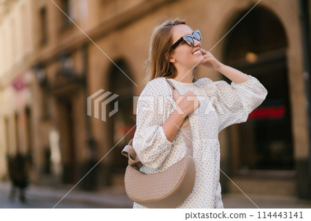 Young beautiful woman walking the streets of an Italian town. Travel and tourism concept. Young beautiful woman walking the streets of an Italian town. Travel and tourism concept. 114443141