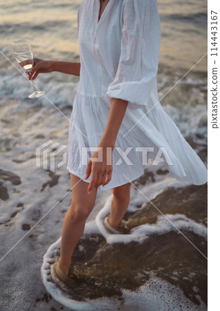 Stylish woman in elegant white dress posing near the sea. People, freedom, lifestyle, travel. Stylish woman in elegant white dress posing near the sea. People, freedom, lifestyle, travel. 114443167