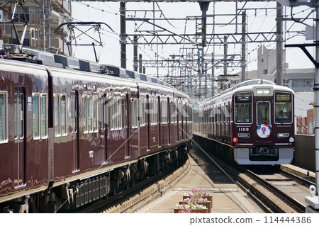 Hankyu trains depart at the same time and run side by side 114444386