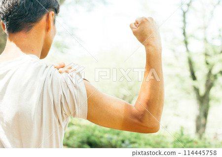 A man with a sunburned arm doing a fist pump 114445758