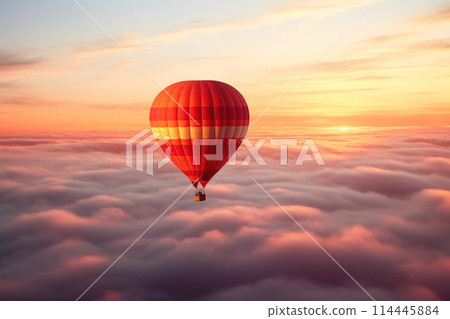 Colorful hot air balloon floats over a sea of clouds at sunset at sunset with orange and blue skies in the background. Travel journey adventure beauty of nature concept 114445884