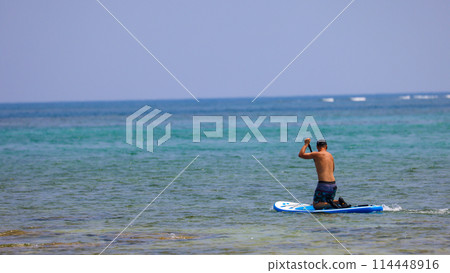 A man enjoying SUP in the beautiful ocean of Okinawa Prefecture 114448916