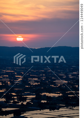 A beautiful sunset view of the sun reflecting off a flooded rice field | Taken from Sankyomura Observation Plaza | Tonami City, Toyama Prefecture 114449049