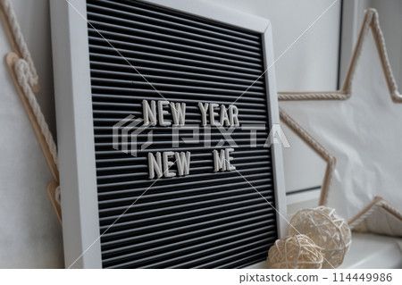 NEW YEAR NEW ME text on black letter board with cozy minimalistic handmade Christmas decor. New year aims resolutions. Low key festive Planning and setting goals NEW YEAR NEW ME text on black letter board with cozy minimalistic handmade Christmas decor. New year aims resolutions. Low key festive Planning and setting goals 114449986