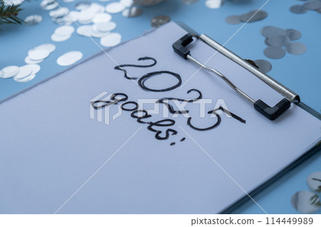 2025 GOALS New year's resolutions on paper note with Christmas decor. Making promises for new year, setting goals. Creating dream vision board 2025 GOALS New year's resolutions on paper note with Christmas decor. Making promises for new year, setting goals. Creating dream vision board 114449989
