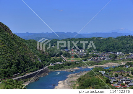 A local train on the Takayama Main Line running along the Kiso River with the fresh greenery of the Japan Line and Mount Ontake in the background 114452276
