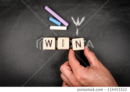 Win Win. Wooden block crossword puzzle and pieces of chalk on a chalkboard background 114453322