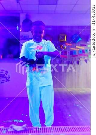 Selfie of a photographer in white clothes smeared with multi-colored paints Selfie of a photographer in white clothes smeared with multi-colored paints 114456323