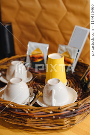 kettle, dishes and tea set on a wicker tray in the glamping room. kettle, dishes and tea set on a wicker tray in the glamping room. 114456460