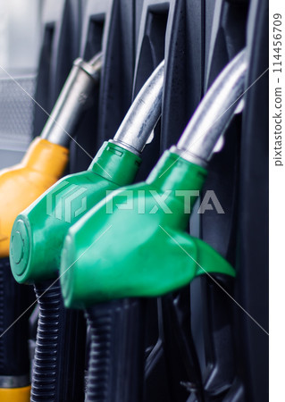 A collection of gas pumps in electric blue, plastic, carmine, and wire 114456709