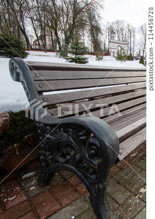 Outdoor bench made of wood placed on brick sidewalk Outdoor bench made of wood placed on brick sidewalk 114456728