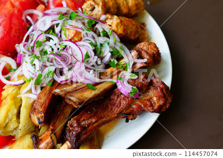 Grilled ribs with marinated onions and grilled vegetables.  114457074