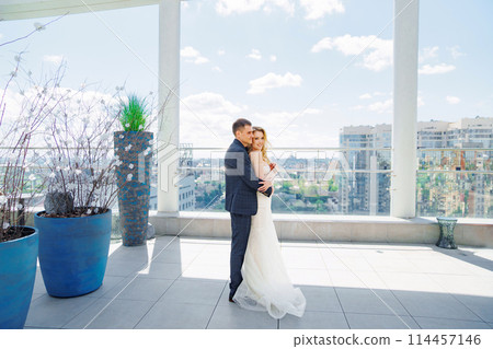 Happy bride and groom on the terrace of a multi-storey hotel. Happy bride and groom on the terrace of a multi-storey hotel. 114457146