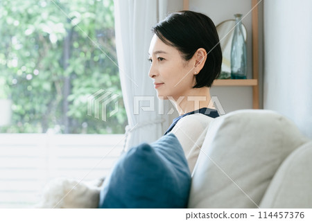 Woman sitting on the couch Woman sitting on the couch 114457376