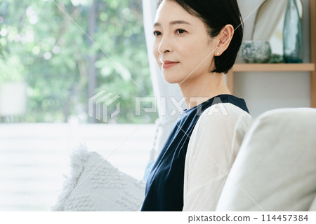 Woman sitting on the couch Woman sitting on the couch 114457384