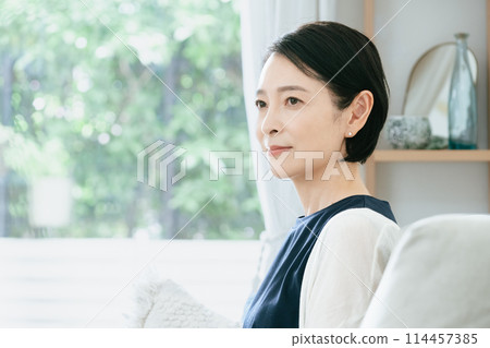 Woman sitting on the couch Woman sitting on the couch 114457385