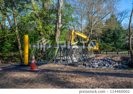 New foot bridge construction installation public park with excavator 114460002