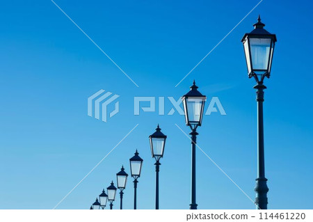 Row of Street Lamps Against a Clear Blue Sky. Generative ai 114461220