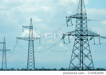 High voltage towers with sky background. Power line support with wires for electricity transmission. High voltage grid tower with wire cable at distribution station. Energy industry, energy saving High voltage towers with sky background. Power line support with wires for electricity transmission. High voltage grid tower with wire cable at distribution station. Energy industry, energy saving 114462699