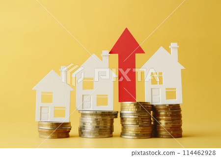 Coins on a table, a red up arrow and house. The concept of the rising price of real estate 114462928