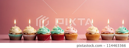 Colorful cupcakes with lit candles are displayed against a pink background, indicating an indoor celebration event marking of joy and celebrating. with free space Colorful cupcakes with lit candles are displayed against a pink background, indicating an indoor celebration event marking of joy and celebrating. with free space 114463366