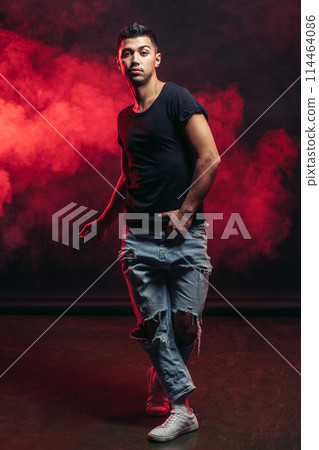 Single young man dancer wearing jeans showing various steps isolated in smoky studio Single young man dancer wearing jeans showing various steps isolated in smoky studio 114464086