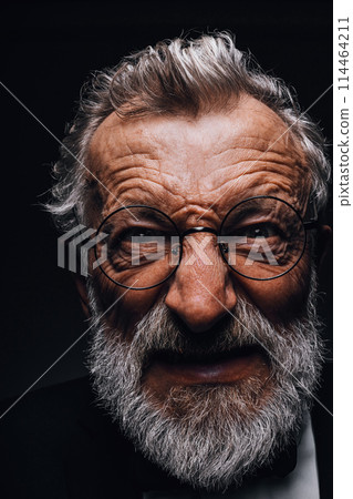 Old man with angry evil horror expression on face, close up on black background 114464211