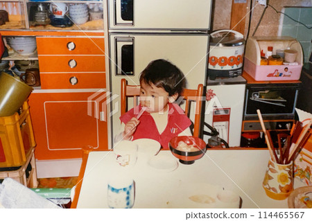 1970s: Girl eating in the kitchen 1970s: Girl eating in the kitchen 114465567