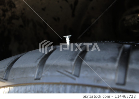 Metal Screw In Vehicle Tire Closeup Metal Screw In Vehicle Tire Closeup 114465728