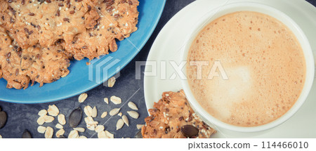 Cup of white coffee and fresh baked oatmeal cookies with honey and healthy seeds Cup of white coffee and fresh baked oatmeal cookies with honey and healthy seeds 114466010