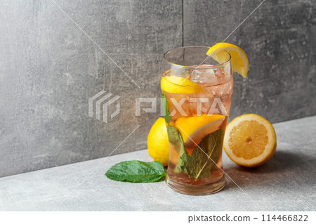 Iced tea with mint and lemon on a grey background. Iced tea with mint and lemon on a grey background. 114466822