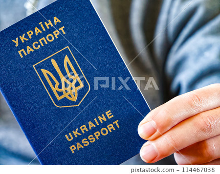 Ukrainian passport in hand, symbolizing readiness for travel and national pride. 114467038